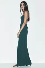 Vestido largo verde esmeralda de tirantes finos ajustables y escote fluido drapeado. Tiene forro interior y cierre trasero con gancho metálico.