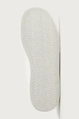 Zapatilla urbana monocolor blanca con cordones al tono, diseño de parte superior lisa, puntera redondeada y suela con volumen.