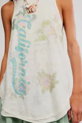 Musculosa blanca de algodón con acabado burnout, diseño sin mangas, espalda nadadora y estampa gráfica frontal con motivos florales y texto.