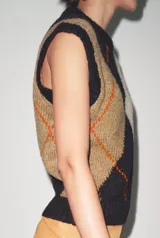 Chaleco de tejido de punto con cuello redondo y manga sisa, presentando un patrón argyle en tonos marrón oscuro, beige y camel, con líneas finas naranjas que delinean los rombos.