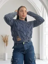 Sweater azul de punto con diseño trenzado y rotura en el abdomen.