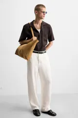 Bolso tipo shopper de piel con acabado serraje color camel, con dos asas de mano y bolsillo interior con cierre de cremallera.