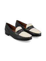 Mocasín de cuero estilo bicolores en negro y marfil, con costuras visibles a contratono y suela de goma.