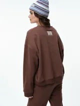 Buzo de cuello redondo y manga larga, con diseño oversize y corte relajado. Presenta puños y ruedo acanalados, confeccionado en tejido de textura suave.