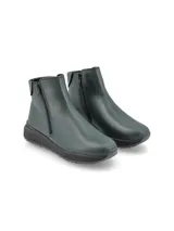 Bota corta de cuero color verde oscuro, con cierre lateral y suela de goma negra tipo plataforma.