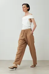 Pantalón de lino color marrón claro, de corte recto y tiro alto, con cintura elástica ajustable con cordón.