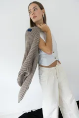 Chaleco plateado con cuello en V, cierre frontal con botones y bolsillos delanteros.