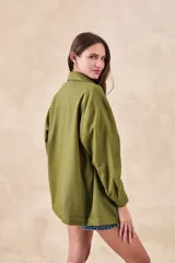 Sobrecamisa verde militar de lino y viscosa, corte oversize, con cuello camisero, cierre frontal con botones, mangas largas con puños abotonados, dos bolsillos de parche con solapa en el pecho y ruedo recto.
