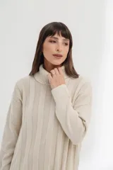 Vestido midi de tejido de punto color crema, con cuello alto, mangas largas y corte recto con aberturas laterales.