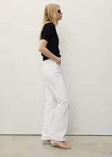 Jeans de corte recto y tiro medio, color blanco, estilo clásico de cinco bolsillos con trabillas para cinturón y cierre frontal de cremallera y botón.