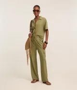 Pantalón largo verde militar de corte fluido, con cintura elástica, cordón de ajuste y bolsillos cargo en los laterales.