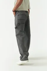 Jean estilo carpenter de corte relajado, recto y amplio, con diseño de cinco bolsillos y costuras reforzadas características del modelo. Presenta un acabado lavado en tono gris oscuro.