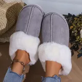 Pantufla cerrada de gamuza gris con interior y borde de peluche blanco, suela de goma antideslizante.