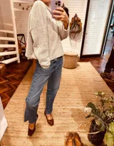 Sweater tejido en boucle color gris, de corte holgado y cuello con capucha.