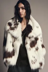 Chaqueta de pelo sintético con estampado animal tipo vaca, cuello solapa, manga larga y forro interior.