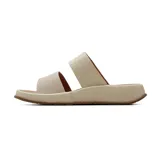 Sandalia plana Korium modelo Sahira de color beige, con dos tiras anchas en el empeine: la frontal con diseño texturizado y aberturas, y la posterior con una hebilla metálica decorativa dorada con la letra E. Suela cómoda de plataforma baja.