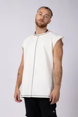 Musculosa oversize de algodón estilo sudadera, color crudo, con costuras visibles en contraste en color negro que recorren el centro verticalmente y enmarcan el cuello y el ruedo.