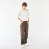 Pantalón de jean con corte baggy y pierna ancha, con efecto de lavado vintage en tono marrón oscuro. Cuenta con diseño clásico de cinco bolsillos, cierre frontal con botón y trabillas para cinturón.