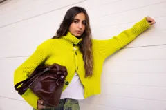 Saco de tejido de punto grueso en color verde lima, con cuello alto tipo polera, diseño holgado y mangas largas.