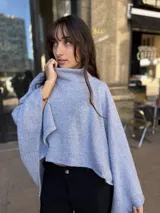 Poncho de hilo liviano en color celeste, con cuello alto y diseño de caída fluida y holgada.