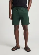 Bermudas de felpa verde oscuro, con corte recto y cordón ajustable en la cintura.