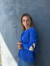 Cárdigan azul con botones, tejido en hilo y apliques plateados en los codos.