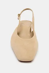 Zapato destalonado de serraje en color beige, con punta cuadrada, tira trasera ajustable con hebilla metálica dorada y tacón ancho bajo.