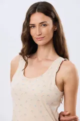 Musculosa de algodón blanca con pequeño estampado floral y volados en los tirantes, de corte clásico.