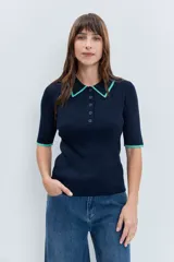 Jersey de punto acanalado en color azul marino, con cuello tipo polo y detalles en color verde menta en el borde del cuello y las mangas. Presenta cierre frontal con botones y mangas cortas.