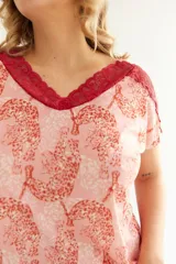 Conjunto de pijama color rosa con estampado de leopardos, detalles de encaje rojo en el escote y mangas de la remera y en el ruedo del short.