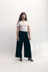 Pantalón palazzo negro con sobrefalda envolvente.