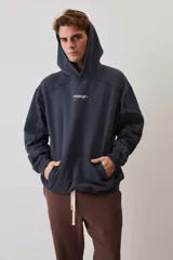 Hoodie canguro de friza en color azul marino, con capucha ajustable, bolsillo frontal tipo parche y estampa tipográfica pequeña en el pecho.