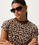 Remera de punto con estampado animal print de leopardo en tonos marrones y beige, de corte regular, cuello alto redondo contrastante y manga corta.