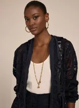 Campera con capucha confeccionada en tejido liso con encaje, con transparencia, corte ajustado, mangas largas con puños elásticos, cintura con cordón para ajustar y cierre de cremallera frontal.