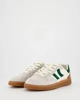 Championes deportivos Coolway modelo Goal, color blanco hueso con detalles en verde oscuro y suela marrón. Confeccionados en serraje y piel, con cordones planos de algodón intercambiables.