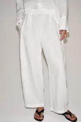 Pantalón de tiro medio confeccionado en 100% lino. Presenta cintura elástica con trabillas, bolsillos laterales, detalle de pinzas en el delantero y cierre frontal con cremallera y botón.