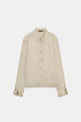 Camisa de manga larga con cuello solapa, confeccionada en tejido satinado con textura de efecto arrugado y cierre frontal mediante botones.