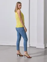 Musculosa negra de poliéster y elastano, con cuello redondo con frunces delanteros y abertura con botón en la espalda.