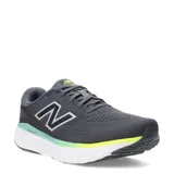 Championes de running New Balance Evoz con tecnología Fresh Foam en la entresuela. Presentan un diseño en color gris oscuro con detalles en verde neón y blanco, confeccionados en malla transpirable con el logo N característico en los laterales.