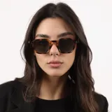 Lentes de sol con armazón de acetato en tono verde oliva traslúcido y cristales oscuros con protección UV400.