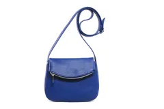 Bandolera negra de cuero con correa larga regulable, solapa con cierre de cremallera y cierre magnético.