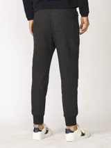 Pantalón jogging de corte slim, con puños elastizados, cintura con cordón ajustable, cierres laterales engomados y bolsillo tipo parche lateral.
