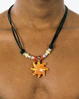 Collar de cordón negro ajustable con dije central en forma de sol de resina naranja y amarilla, decorado con cuentas metálicas, rojas y amarillas.