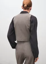 Chaleco de sastre color gris, con cuello en V, sin mangas, bolsillos de ribete laterales y cierre frontal con botones.