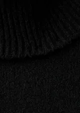 Vestido corto de punto negro con cuello alto vuelto y mangas largas de corte recto.