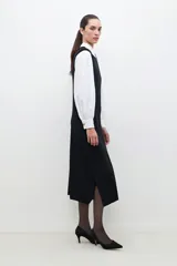 Vestido midi negro de tejido de punto, sin mangas, con cuello redondo y hombreras.