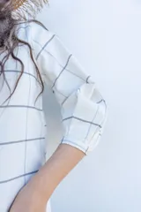 Vestido midi de diseño a cuadros, con cuello redondo, cierre frontal de botones y mangas tres cuartos abullonadas.