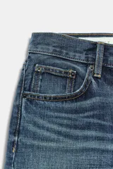 Jeans de tiro medio con corte straight, color azul con efecto lavado y roturas sutiles, cinco bolsillos y cierre frontal con cremallera y botón metálico.