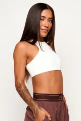 Top deportivo de cuello alto y diseño minimalista, confeccionado en poliamida con elastano, con forro interno para mayor soporte y comodidad.