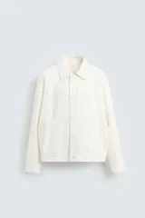 Cazadora de hombre, corte regular fit, color blanco roto, confeccionada en tejido de lino y algodón. Presenta cuello solapa, manga larga con puños abotonados, bolsillos de plastrón en la cadera y cierre frontal de botonadura.